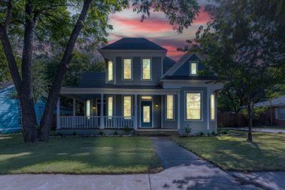 View of front facade featuring covered porch and a yard | Image 1