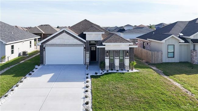 View of front of home with a front yard, fence, a garage, cooling unit, and driveway | Image 5