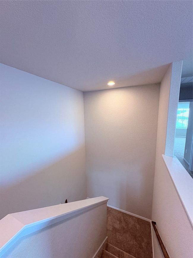 Staircase featuring carpet flooring, a textured ceiling, and recessed lighting | Image 37
