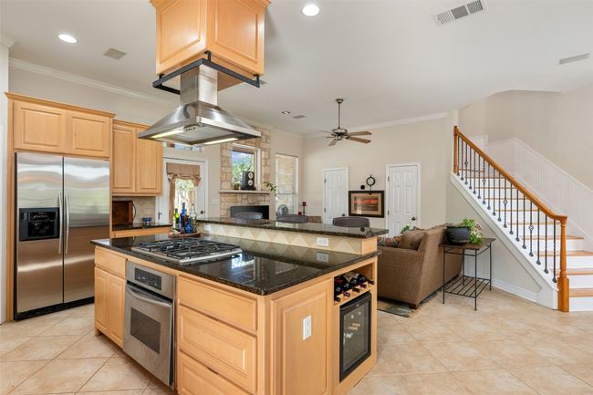 Kitchen touts appliances with stainless steel finishes, maple cabinetry, island exhaust hood, and granite counters. | Image 6