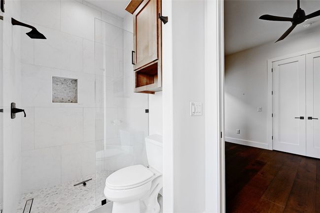 Full bathroom with ceiling fan, wood-type flooring, toilet, and a stall shower | Image 29