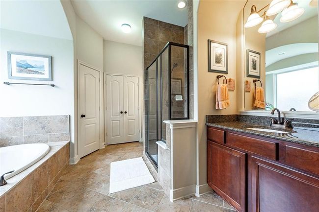 Gorgeous primary bath with dual vanities, granite counter tops, walk-in glass door shower and separate tub. | Image 35