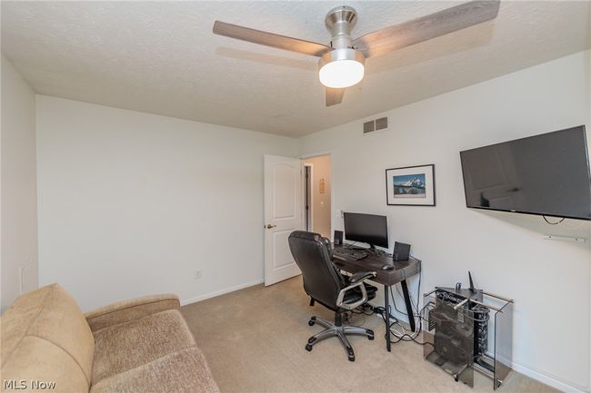 Carpeted home office featuring ceiling fan and a textured ceiling | Image 36