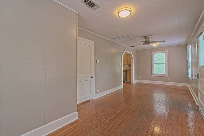 Spare room with ceiling fan, wood finished floors, arched walkways, and ornamental molding | Image 9