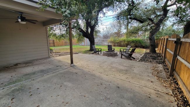 Fenced backyard with an outdoor fire pit, a ceiling fan, and a patio area | Image 20