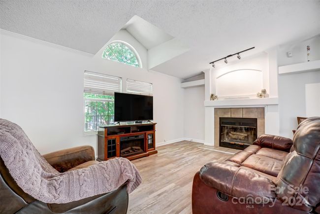 The fireplace brings a sense of coziness to the living room. | Image 7