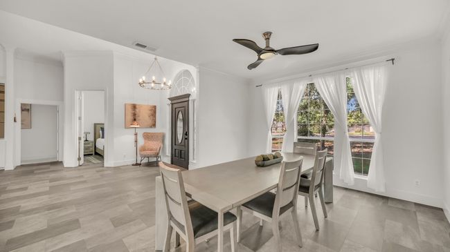 Dining area with ornamental molding, a ceiling fan, and a chandelier | Image 8