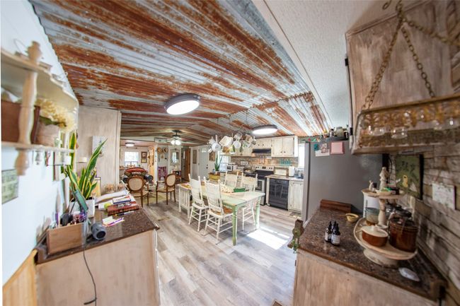 Kitchen with backsplash, vaulted ceiling, ceiling fan, light wood-type flooring, and appliances with stainless steel finishes | Image 6