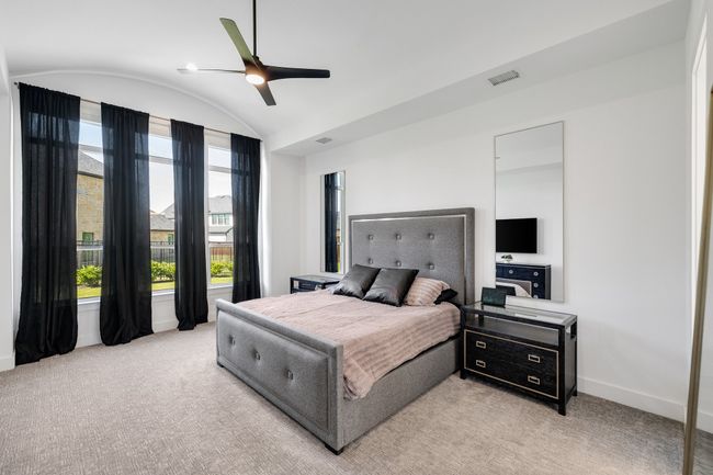 Bedroom with baseboards, lofted ceiling, light carpet, and a ceiling fan | Image 18