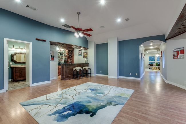 The upstairs recreation room has a full bar area, an attached bathroom and plenty of space for a pool table, foosball, or game tables and couches. | Image 24