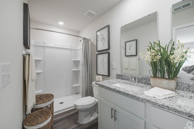 Full bath with double vanity, wood finished floors, and a shower with shower curtain | Image 12