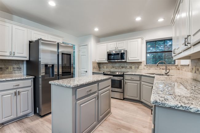 Kitchen with gray cabinetry, stainless steel appliances, tasteful backsplash, light wood-style flooring, and recessed lighting | Image 9