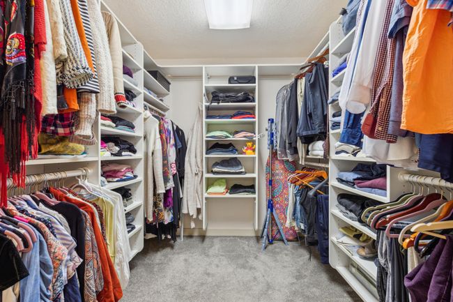Expansive walk-in closet with built-in shelving, abundant hanging space, and custom organization for both wardrobe and accessories. | Image 17