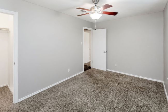 Unfurnished bedroom with carpet, ceiling fan, a closet, and a walk in closet | Image 26