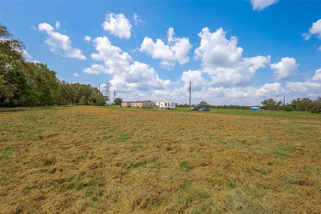 This wider perspective emphasizes the scale of the property and how each element—residence, RV, and secondary home—rests with purpose on the land. | Image 41