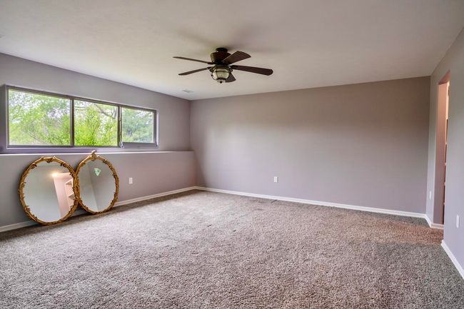 Carpeted spare room featuring ceiling fan and baseboards | Image 30