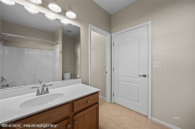 Bathroom featuring tile patterned floors, toilet, a shower, vanity, and visible vents | Image 20