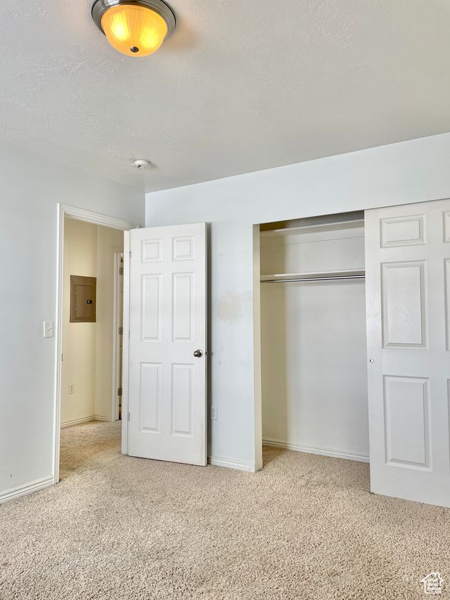 Unfurnished bedroom with carpet, a closet, baseboards, and electric panel | Image 21