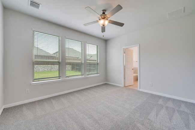 Empty room with light carpet and a ceiling fan | Image 6