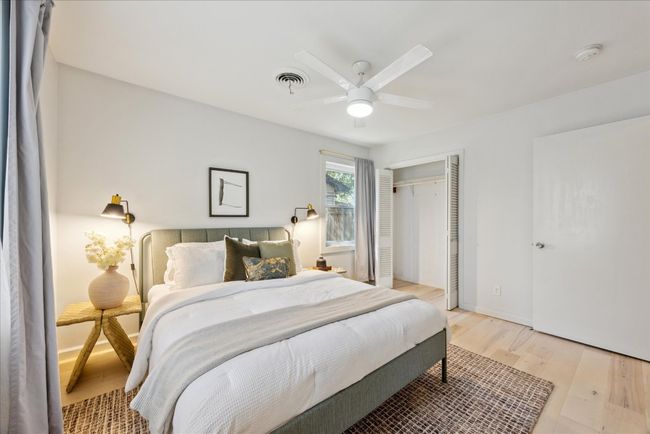 Bedroom with visible vents, a closet, light wood-style floors, baseboards, and ceiling fan | Image 16