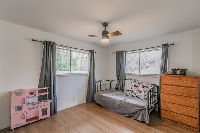 Bedroom featuring wood finished floors, a ceiling fan, and crown molding | Image 14