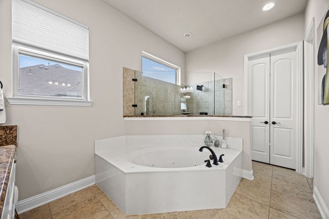 Full bath featuring a tub , a walk in shower, healthy amount of natural light, and baseboards | Image 17