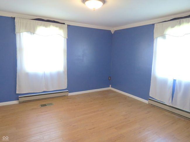 spare room featuring light wood-type flooring, a baseboard heating unit, baseboards, and ornamental molding | Image 8