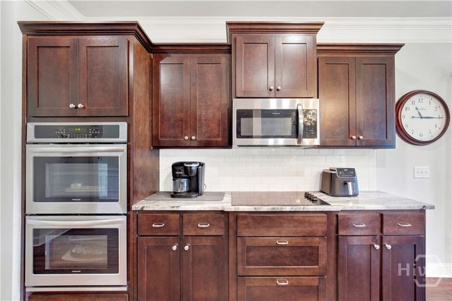 Holidays and family gatherings will be a breeze with this Chef's kitchen! Double ovens and separate cooktop, upgraded granite countertops, and tile backsplash. | Image 13