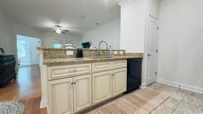 Kitchen with cream cabinetry, dishwasher, ceiling fan, a peninsula, and ornamental molding | Image 18