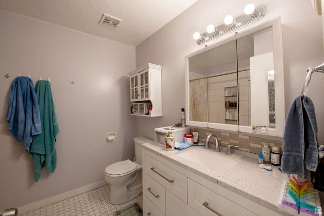 Bathroom with vanity, toilet, visible vents, baseboards, and a shower with shower curtain | Image 11