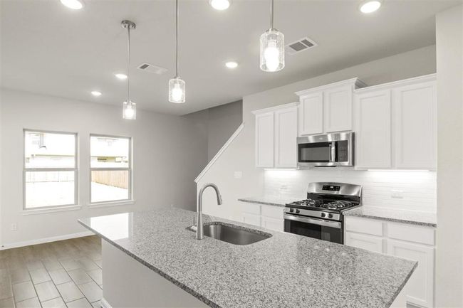 Kitchen featuring stainless steel appliances, tasteful backsplash, visible vents, and a sink | Image 17