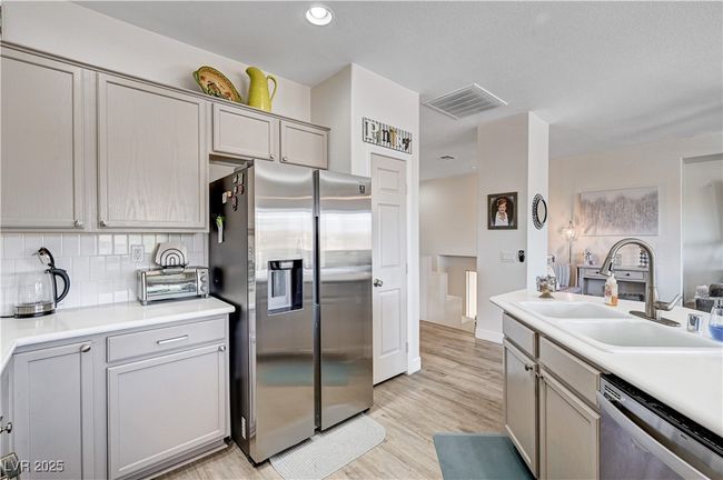 Kitchen with appliances with stainless steel finishes, backsplash, light wood-style flooring, light countertops, and gray cabinetry | Image 8