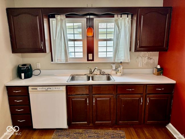 kitchen with dishwasher, light countertops, dark wood-type flooring, and dark brown cabinets | Image 19