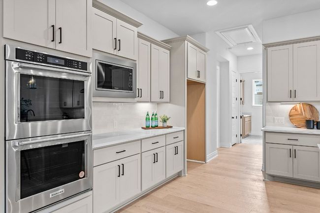 Kitchen featuring double oven with stainless steel finishes, light countertops, tasteful backsplash, recessed lighting, and light wood-type flooring | Image 9