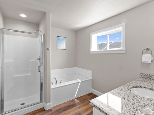 Bathroom with wood finished floors, a shower stall, a bath, and vanity | Image 14
