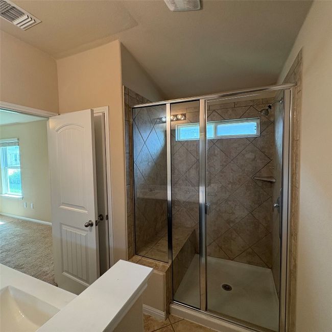 Bathroom with a stall shower, vanity, and light tile patterned flooring | Image 10