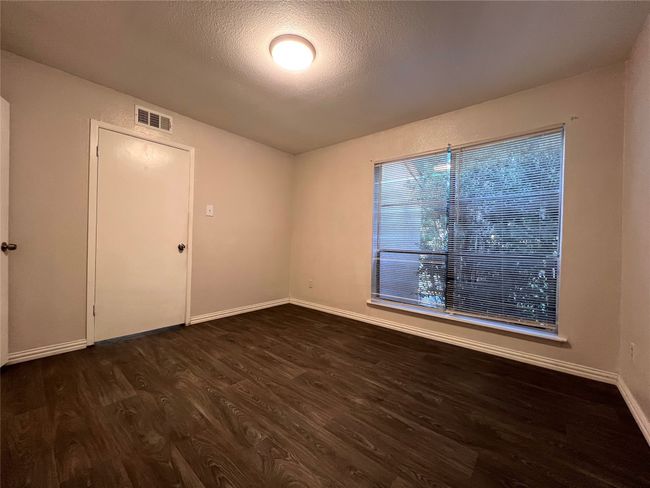 Spare room with dark wood-type flooring, baseboards, and a textured ceiling | Image 4