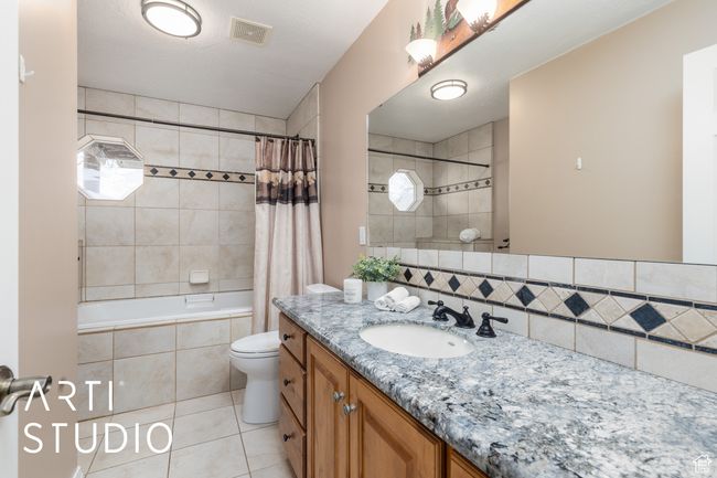 Bathroom with vanity, tile patterned flooring, backsplash, toilet, and visible vents | Image 32