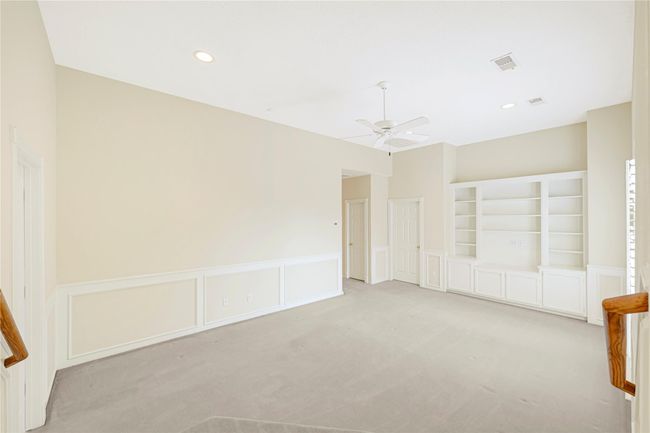 Spacious game room featuring elegant custom built-ins for stylish storage and display. | Image 35