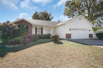 Ranch-style house with a front yard and a garage | Image 1