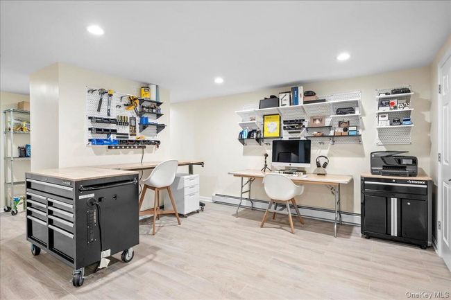 Office space featuring wood finished floors, a baseboard heating unit, recessed lighting, and baseboards | Image 31