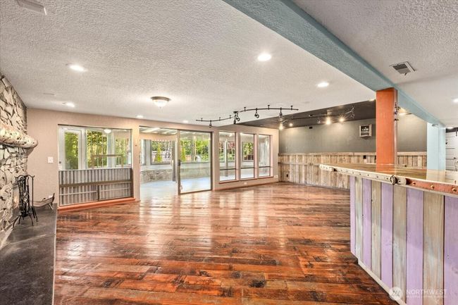 Lower-level rec room with wet bar and cozy fireplace—perfect for entertaining, a media room, or game space. Sliding door leads to the sunroom | Image 22