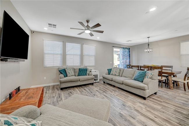 Living area with light wood-style floors, ceiling fan, recessed lighting, a chandelier, and baseboards | Image 10