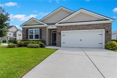 View of front of home featuring a front lawn and a garage | Image 1