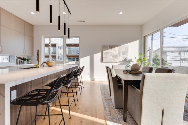 Kitchen featuring a kitchen breakfast bar, gray cabinets, hanging light fixtures, and light hardwood / wood-style flooring | Image 16