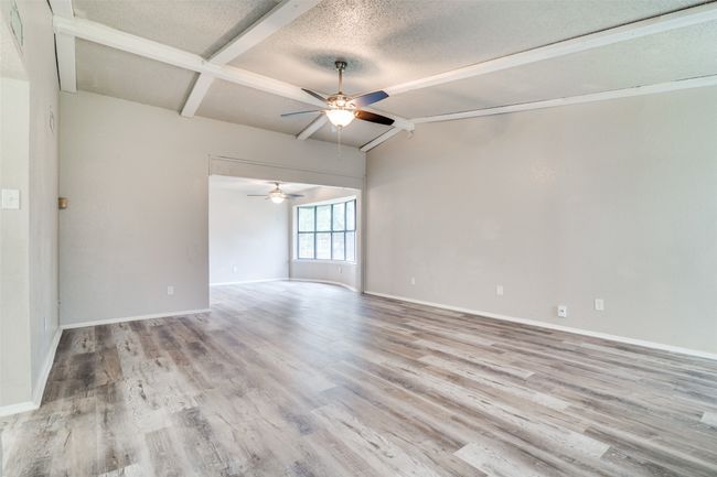 Empty room featuring ceiling fan, wood finished floors, and a textured ceiling | Image 7