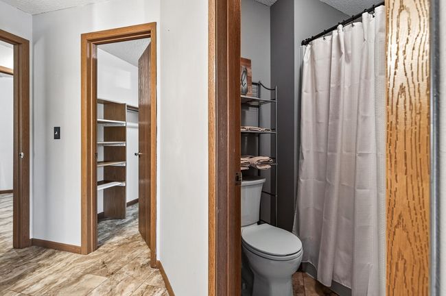 There is a private shower and toilet room in the primary bathroom. The beautiful luxury vinyl tile flooring runs throughout the space in the primary en suite. | Image 16