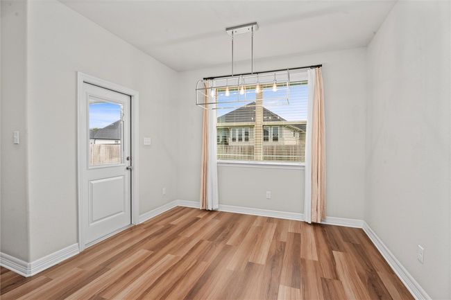 Unfurnished dining area with light wood-type flooring, plenty of natural light, and baseboards | Image 13