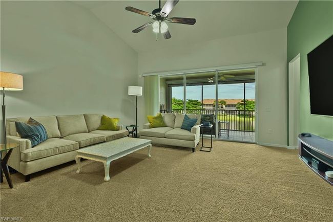 Living room with light colored carpet, high vaulted ceiling, and ceiling fan | Image 6