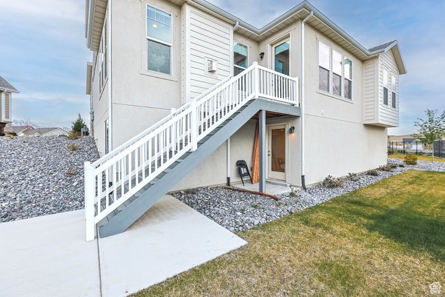 Back of house with a patio area, a lawn, and stucco siding | Image 38